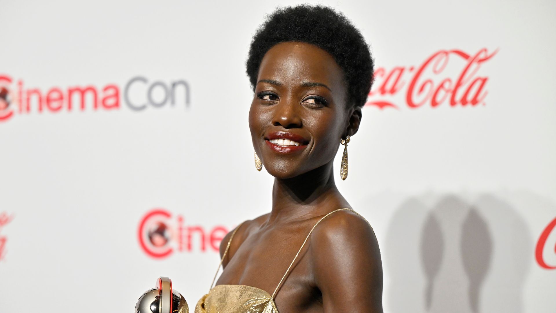 Lupita Nyong’o is a goddess in molten gold backless gown