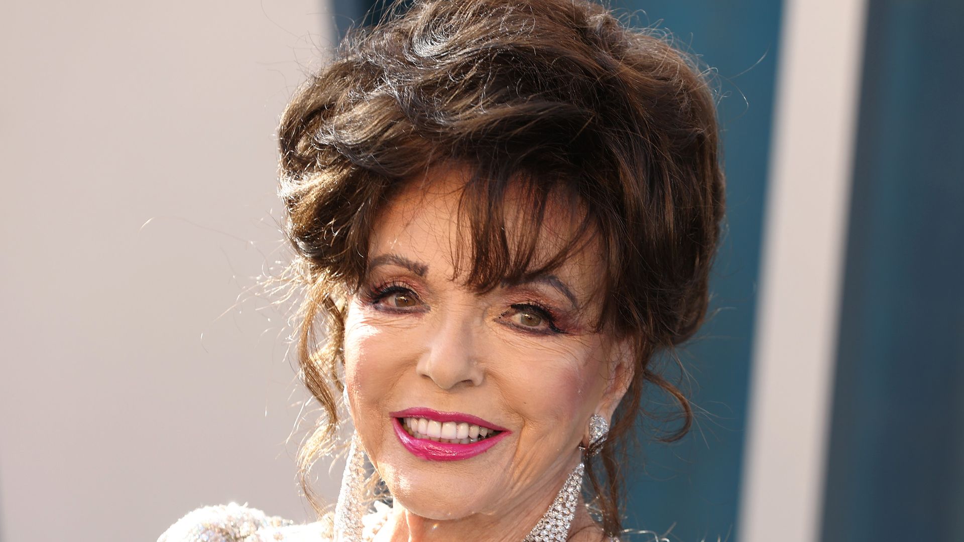 Joan Collins, 90, shows off unbelievable legs in a daring black halterneck swimsuit
