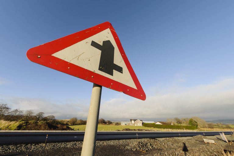 What is a staggered junction warning sign and what does it mean?